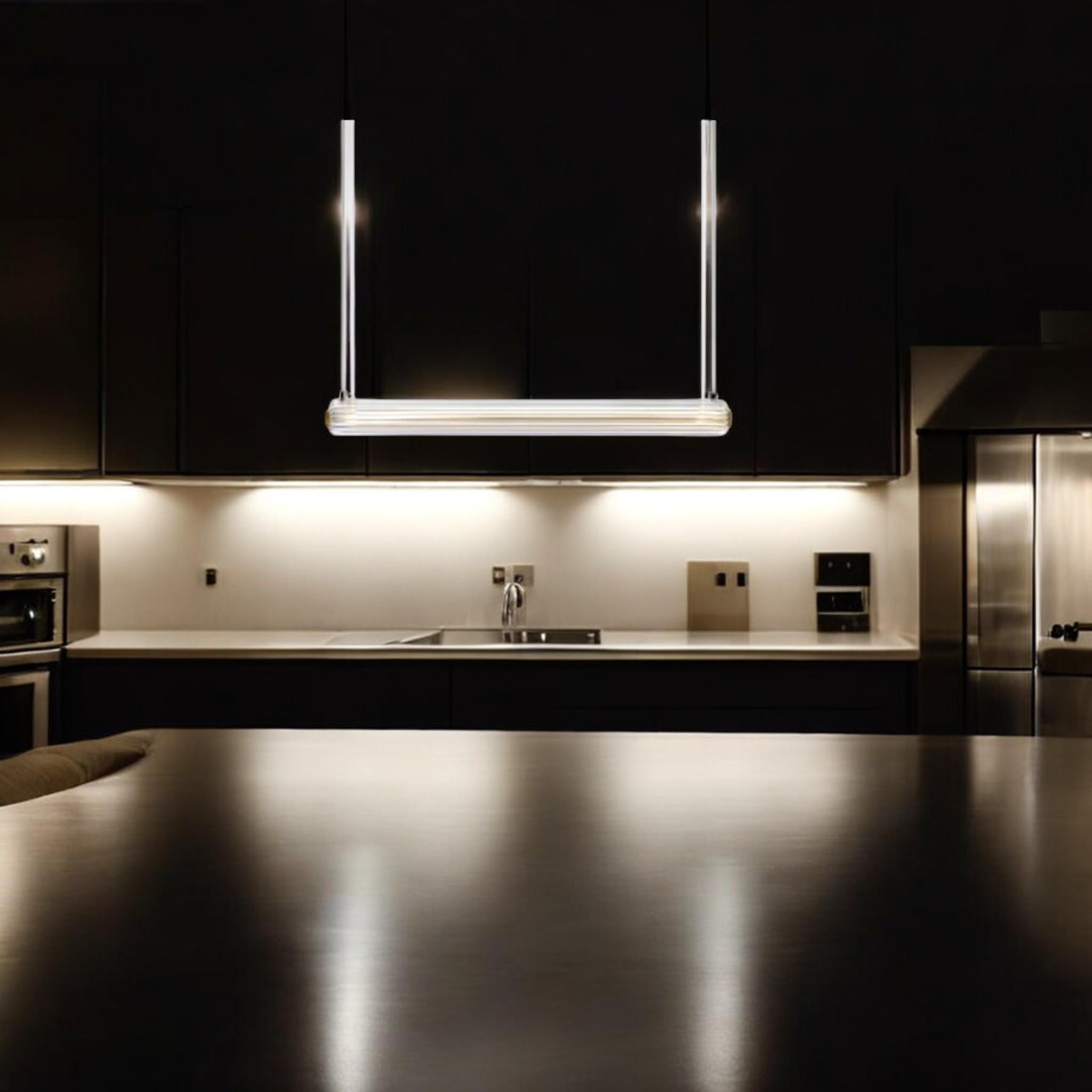 Custom glass pendant light illuminating a modern kitchen countertop with stainless steel appliances.